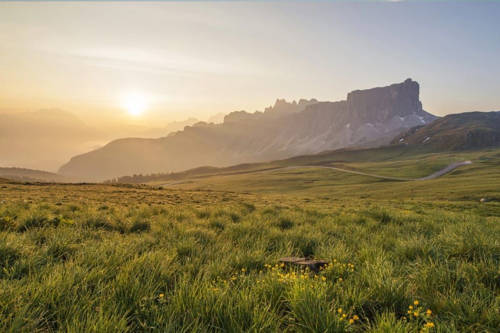 Landscape photograph of fields and mountain with sun rising