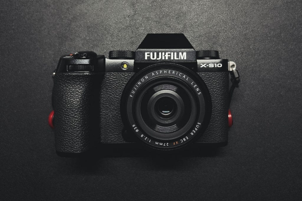 Fujifilm X-S10 mirrorless camera laying lens up on a black surface