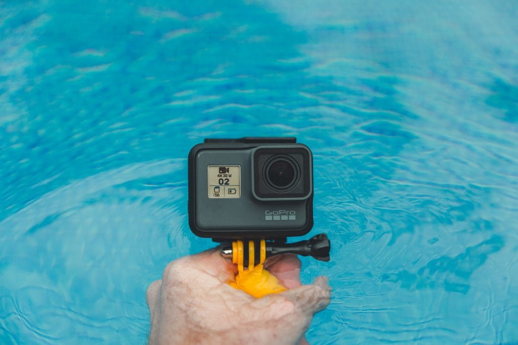 gopro camera for underwater photography held above pool
