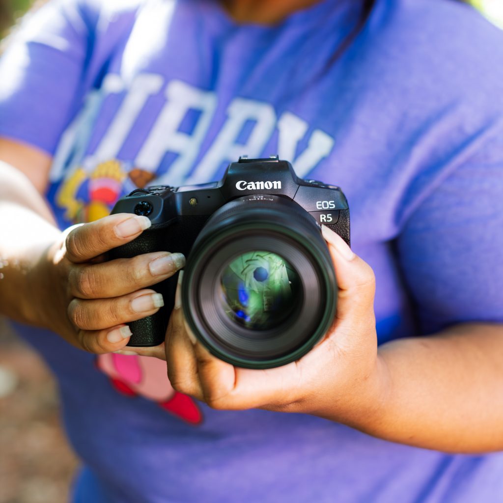 Close-up photo of Canon EOS R5 camera being held by KEH staff member Constance.
