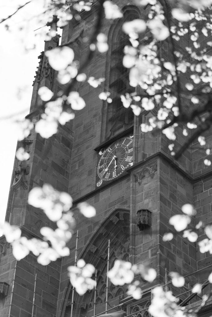 Black and white image of a clock on the side of a building.